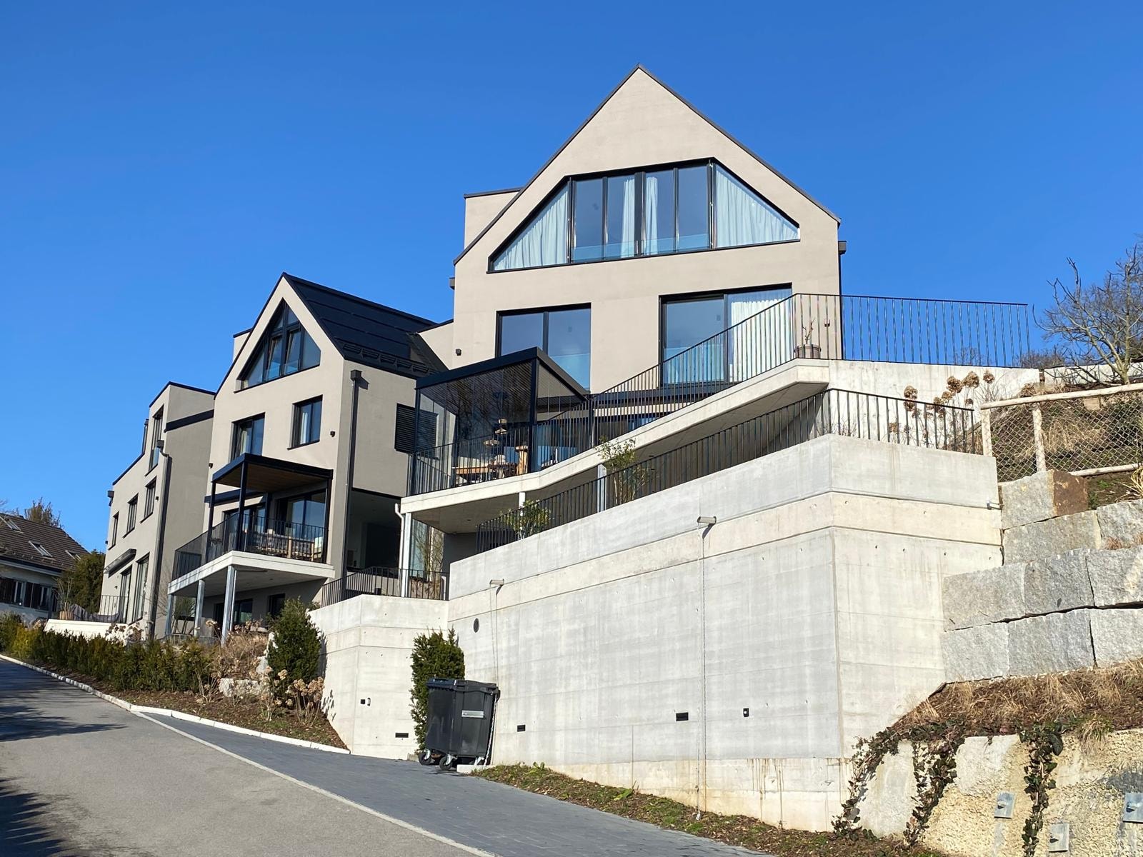 Moderne Terrassenhäuser mit Giebeldächern an einem Hang